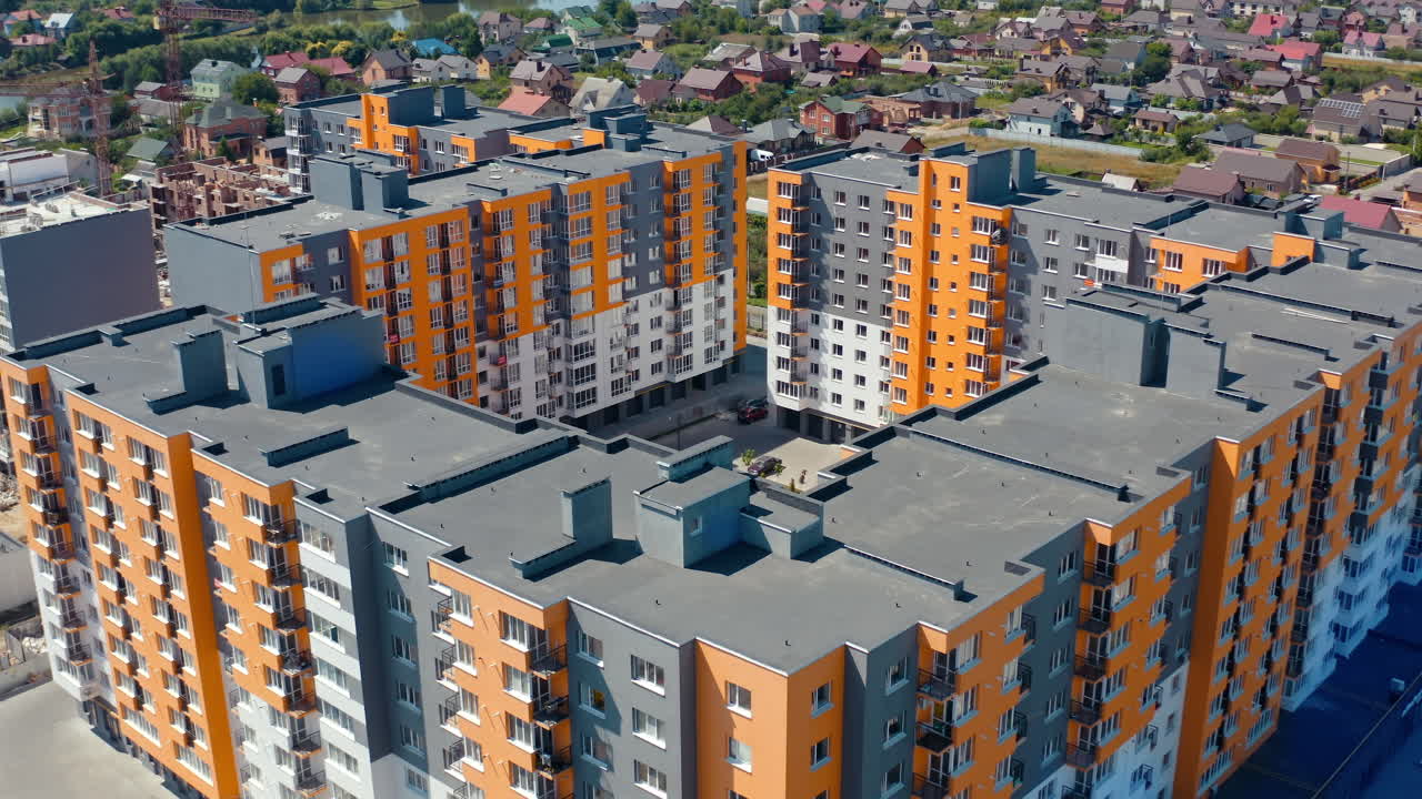 New architecture in the town. Residential cityscape construction. Modern complex of colorful high-rise buildings for residents of the city. Aerial view.