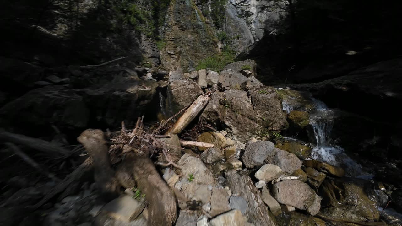 Waterfall in Switzerland, forrest, nature, mountain creek. FPV aerial video. Adventure, outdoor and nature exploration