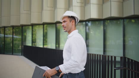 confident engineer talking walkie-talkie walking district closeup. man working