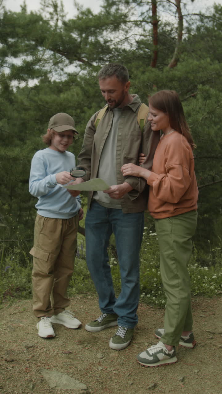Family hiking in the forest with a map