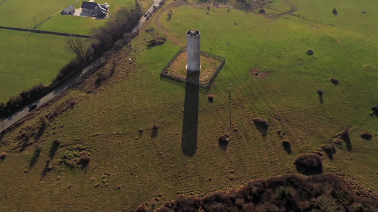 Dynamic top-down aerial view of large water tower in Clarinbridge, Galway