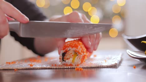 making sushi at home kitchen. woman hands rolling homemade sushi.