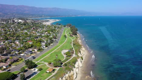 Drone-shot-panning-down-of-a-cliff-on-the-beach-in-Santa-Barbara,-California