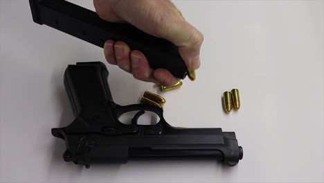 person emptying bullets ammunition from a firearm magazine