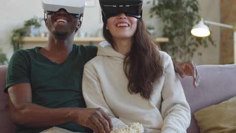 cheerful diverse couple watching movie on vr headsets