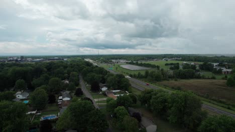 Toma-De-Adelantamiento-De-La-Carretera-Principal,-Largo-Camino-Cerca-Del-Campo-De-Paneles-Solares-Bajo-Un-Cielo-Nublado,-Ohio