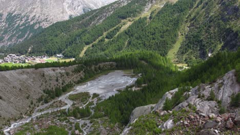 aerial view of glacier lake and pine trees in saas fee, switzerland, revealing shot of mountain village saas-fee in the swiss alps