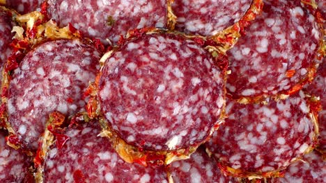 pieces of salami with spices rotate slowly.