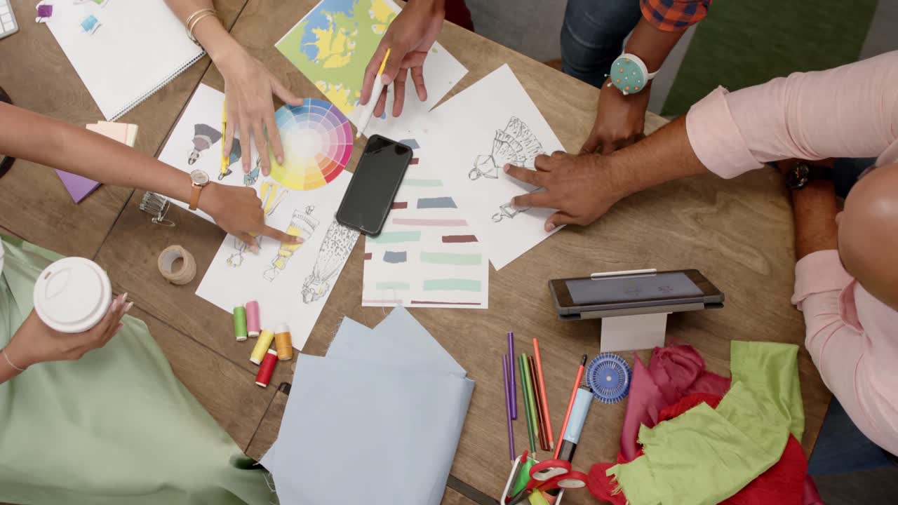 mesa y sección media de diversos diseñadores en una reunión de diseño en un estudio de moda, en cámara lenta