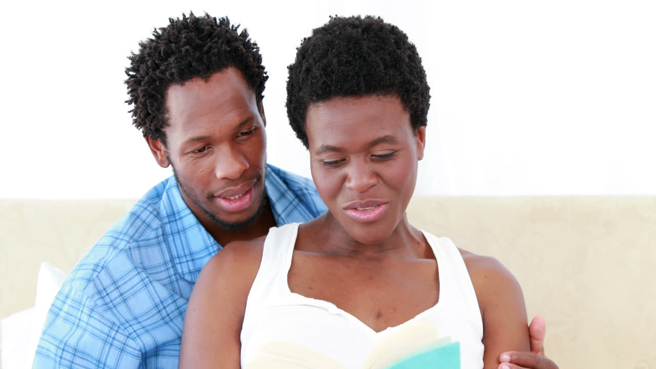 Pregnant woman and her husband reading a book