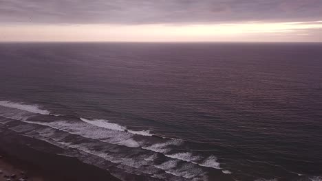 beautiful purple sunset over the waves of ecuador by olon beach -aerial ascend