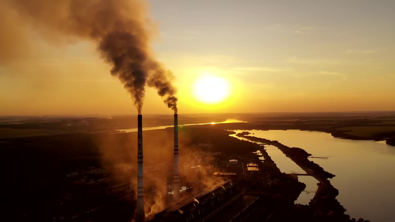 Fuming pipe plant. Smoking pipes of power plant during sunset