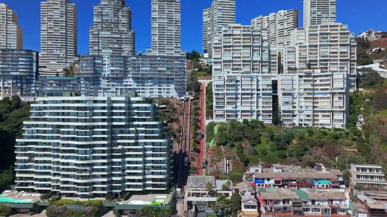 Vista aérea em movimento de aproximação de um funicular particular em um condomínio residencial moderno em Concón, Chile, em um dia ensolarado.
