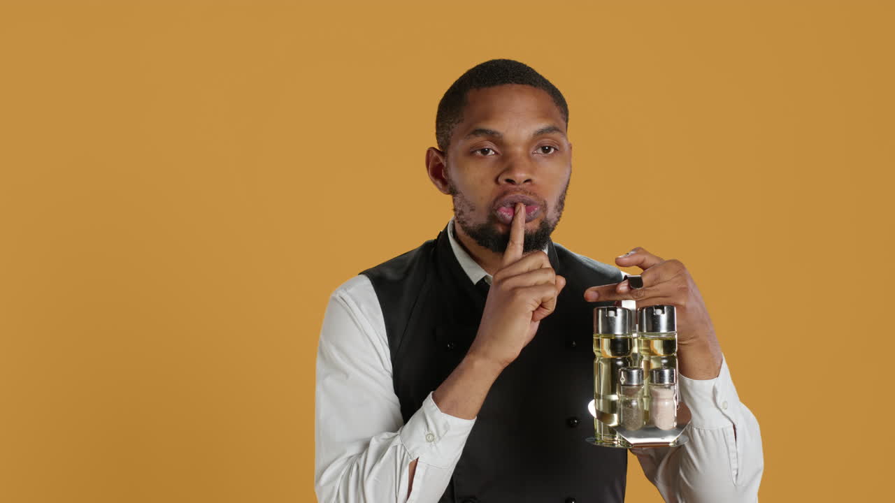 camarero del personal de catering haciendo una señal muda para el silencio y la privacidad