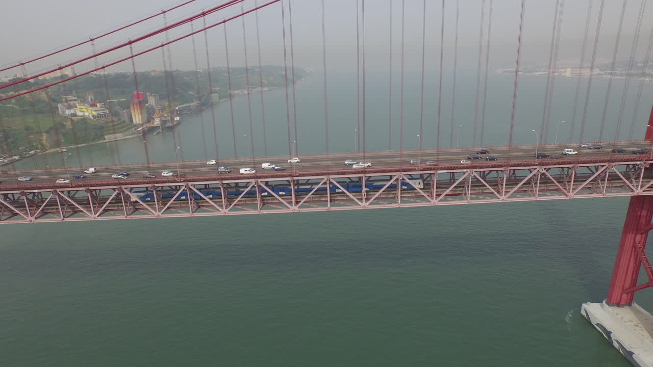 toma lateral siguiendo un tren bajo el puente lisboa 25 de abril en portugal