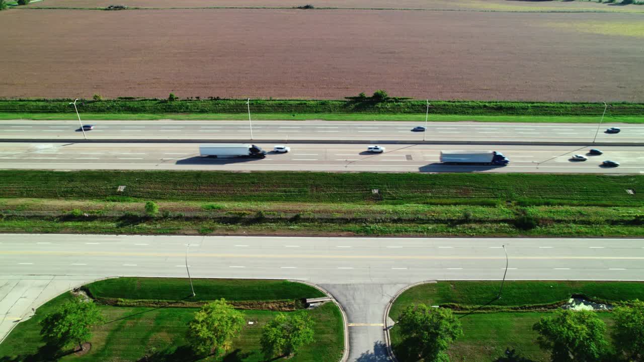 Side View of semi trucks and trailers driving on interstate