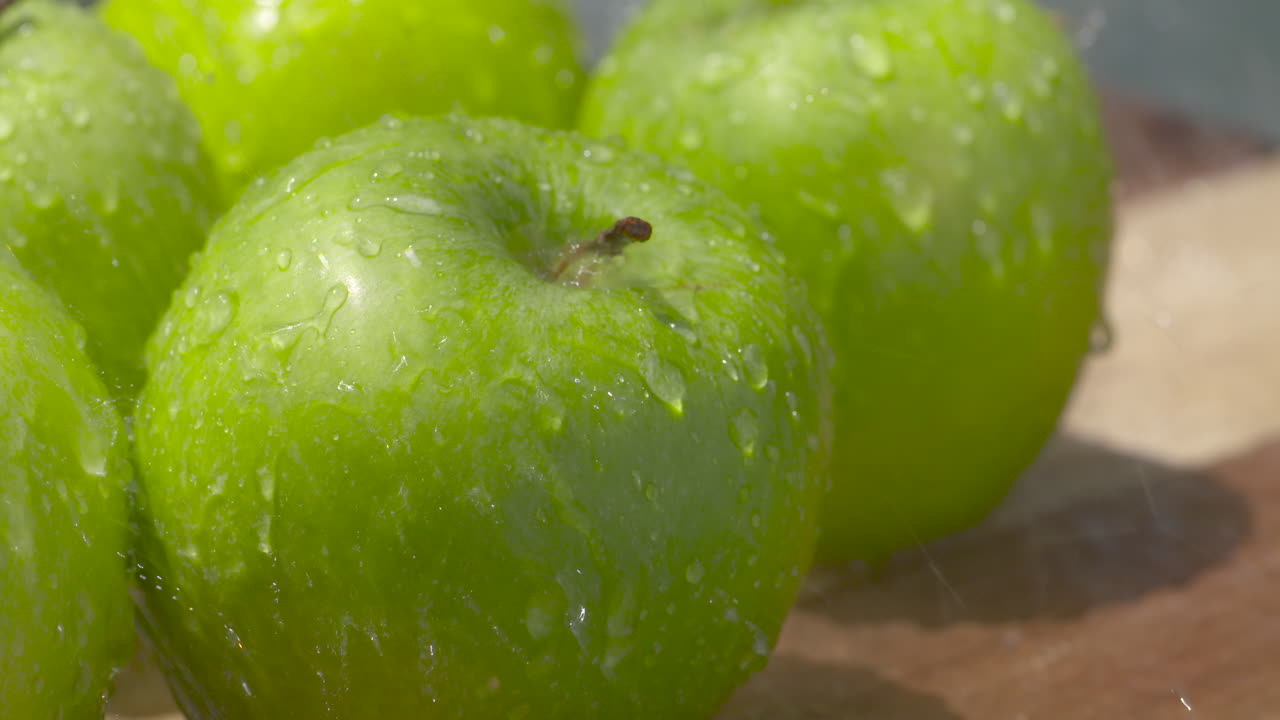 lavar un montón de manzanas granny smith frescas, brillantes y verdes a la luz del sol