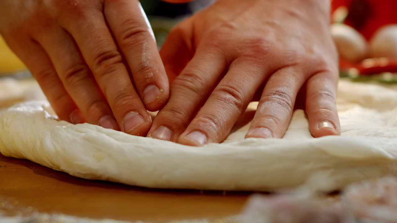 Hands kneading pizza dough
