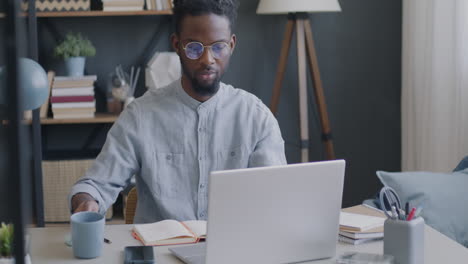 hombre trabajando desde casa en una computadora portátil