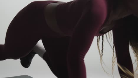 studio shot of two women wearing gym fitness clothing facing each other exercising 5