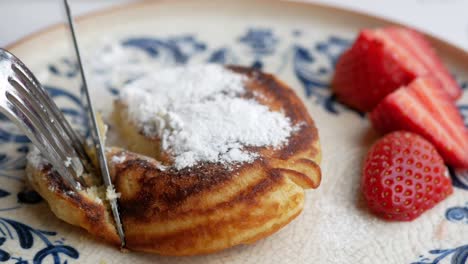 comida sabrosa con bayas y pastel de sartén en un cuenco sobre fondo negro,