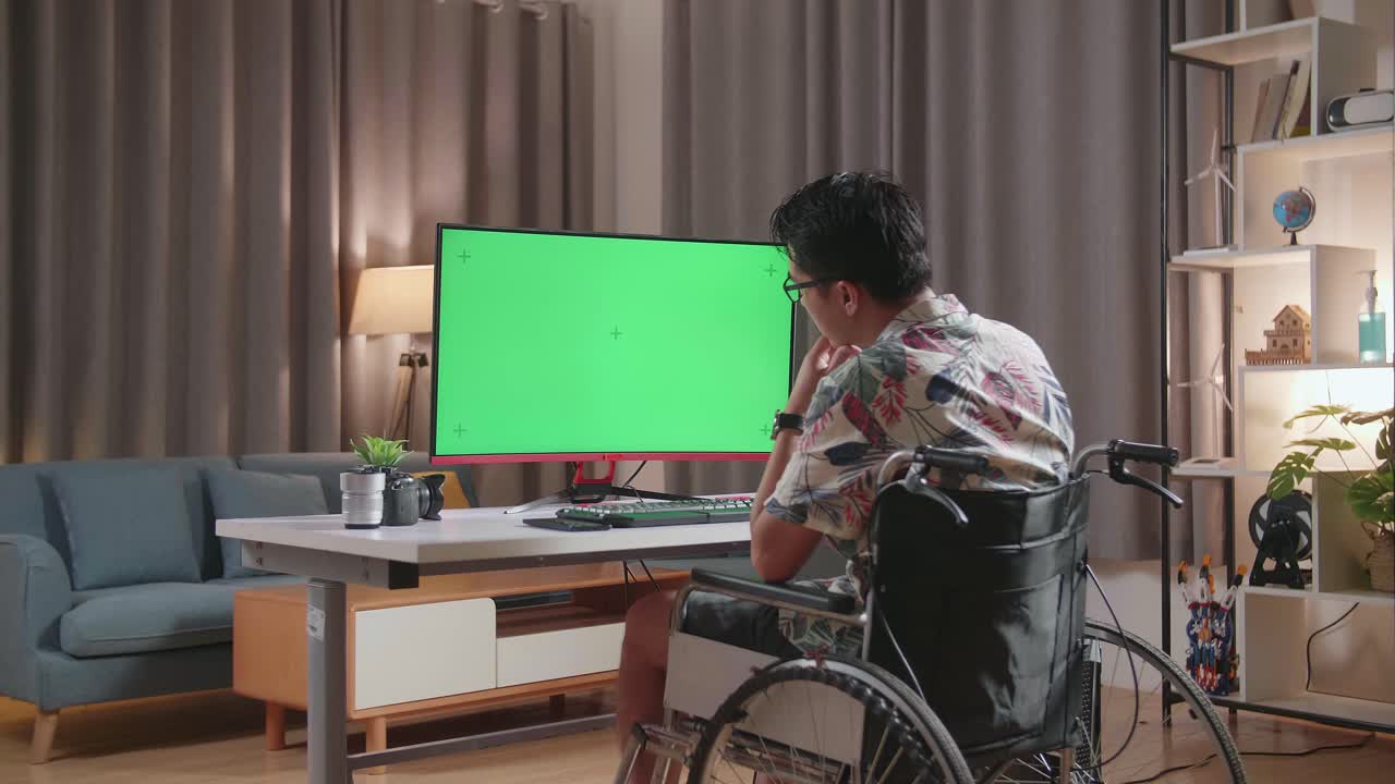 Person in Wheelchair Working on Computer with Green Screen