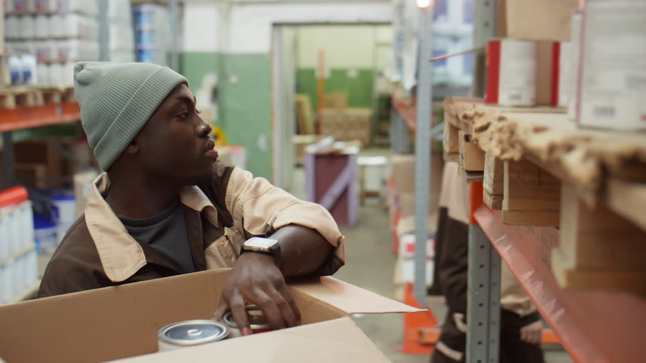Warehouse worker stocking and packing paint cans
