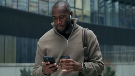 man using smartphone while walking in city