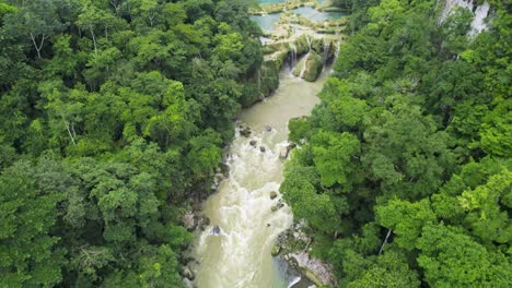 Drone-aerial-footage-of-Guatemalan-river-Rio-Cahabon-and-rainforest-Semuc-Champey-National-Park-surrounded-by-bright-green-rainforest-hillsides-and-mountains