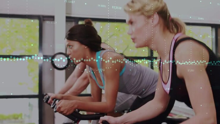 Three cyclists starting on coach cue, riding for fitness, data overlay mapping flywheel cadence
