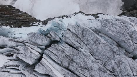 drone volando sobre la pared de hielo y roca del glaciar fellaria, valmalenco en italia