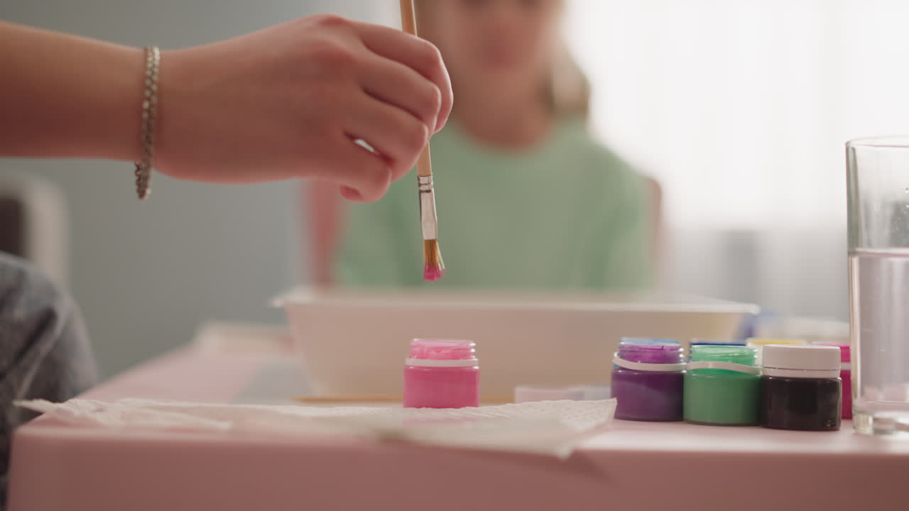 la dama toma pintura rosa con pincel para mostrar el dibujo de la chica ebru