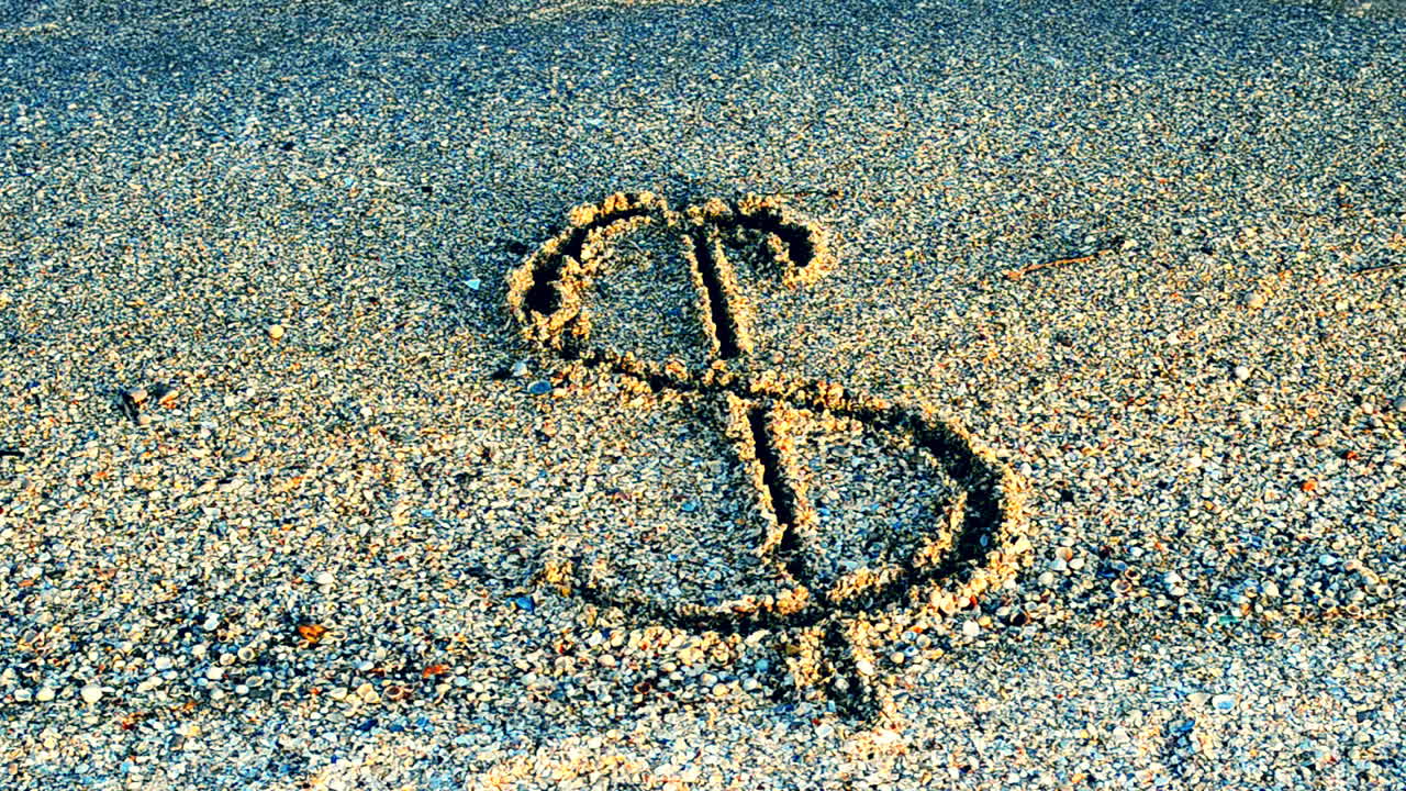 Símbolo do dólar na areia. Areia e moeda