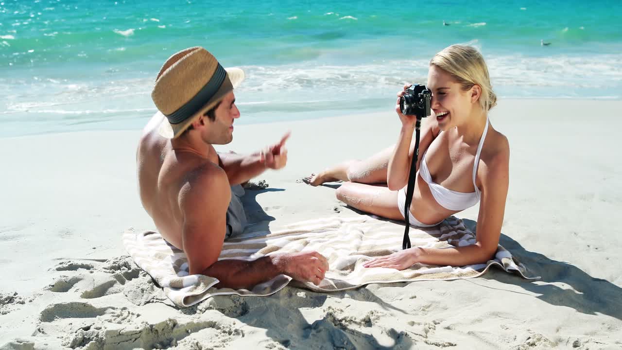 женщина фотографирует мужчину с камерой.