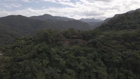 A-serene-drone-pullout-unveils-a-cozy-shack-nestled-within-the-serene-Sierra-Madre-mountain-range-in-Jalisco,-Mexico