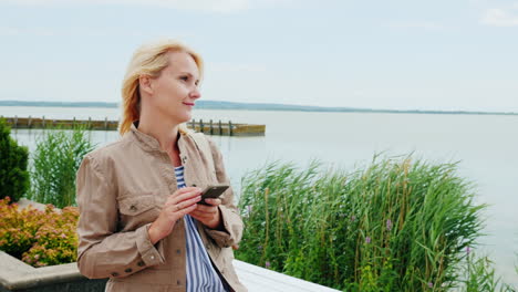 Woman-Walking-Around-Lake-Using-Phone