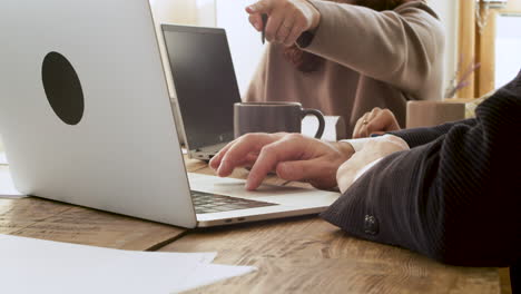 Close-Up-Of-Two-Unrecognizable-Business-People-Debating-While-Using-Laptop-Computer