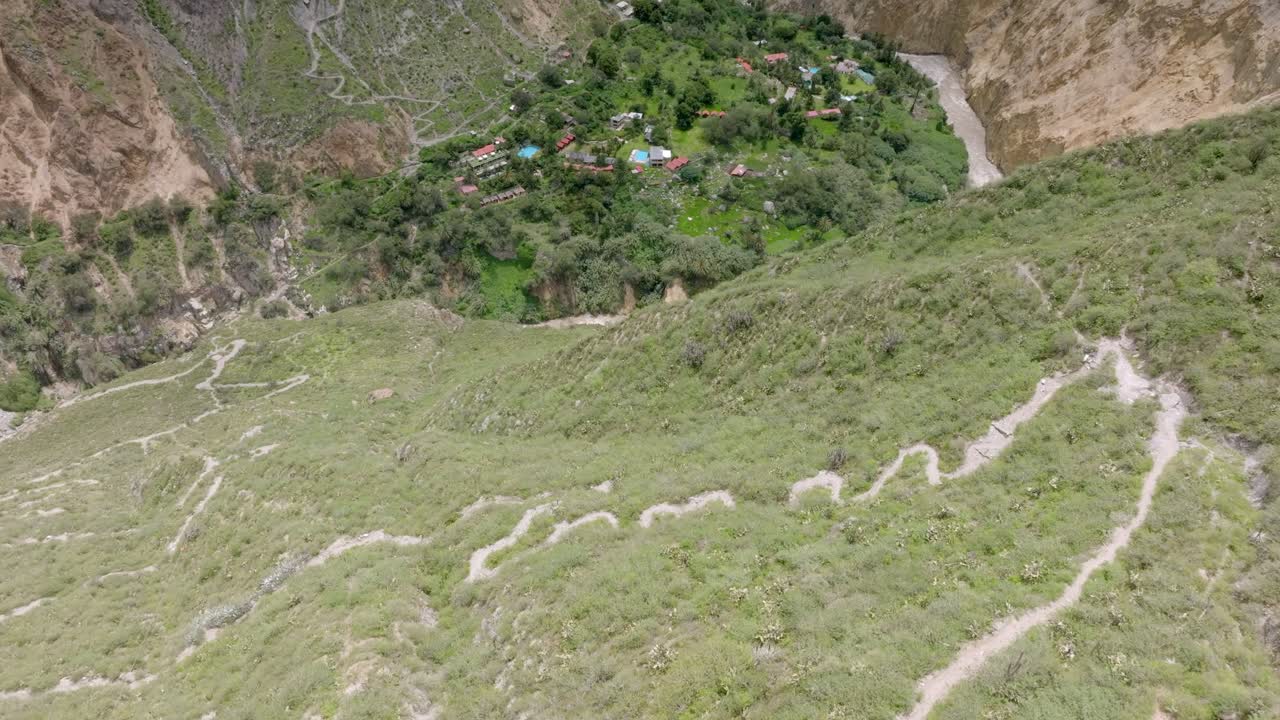 Drone shot capturing the descent along the winding path from Malata to the lush Sangalle Oasis, nestled in the depths of the Colca Canyon.