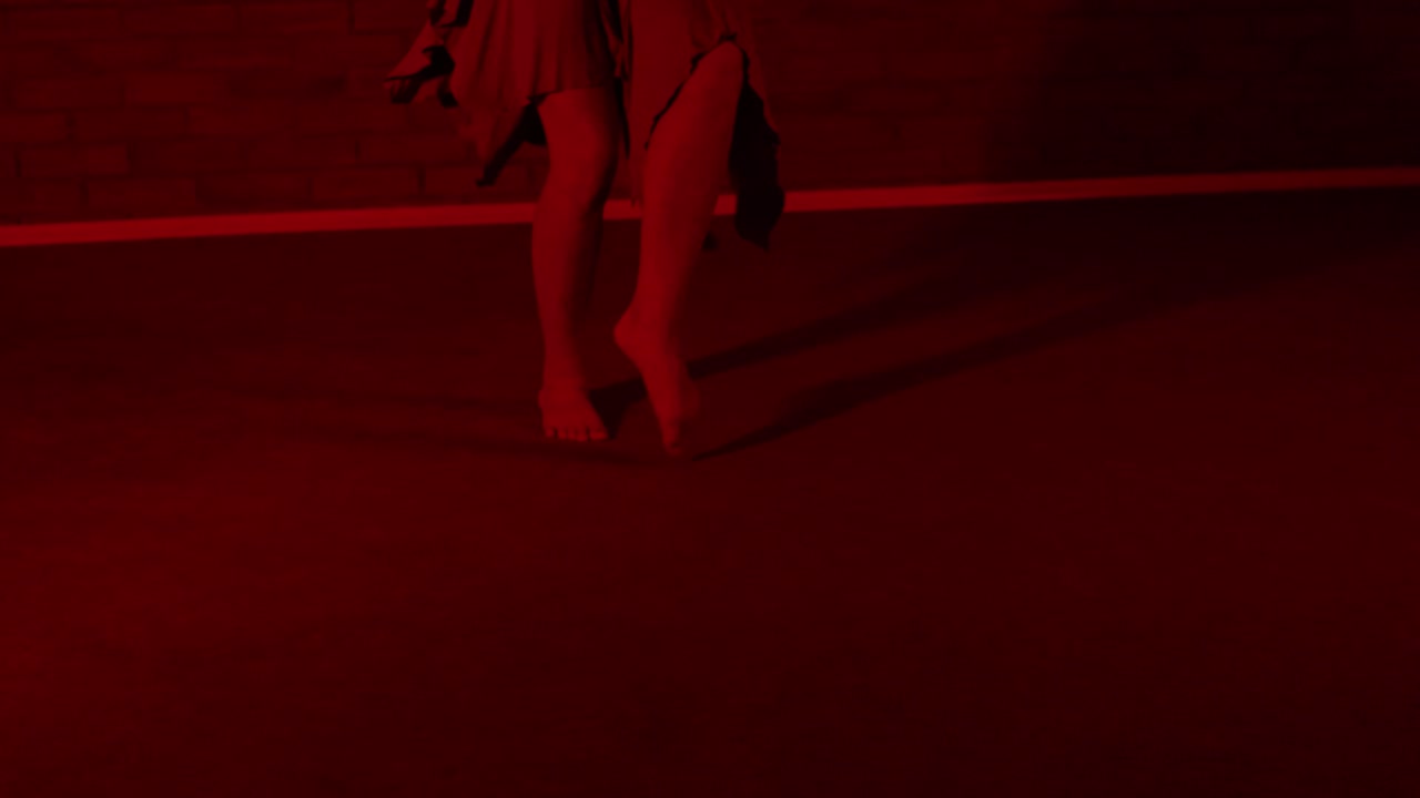 vista de pies descalzos de una bailarina bailando en una habitación roja