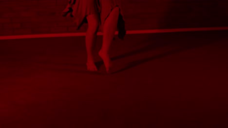 bare feet view of a female dancer dancing in a red room