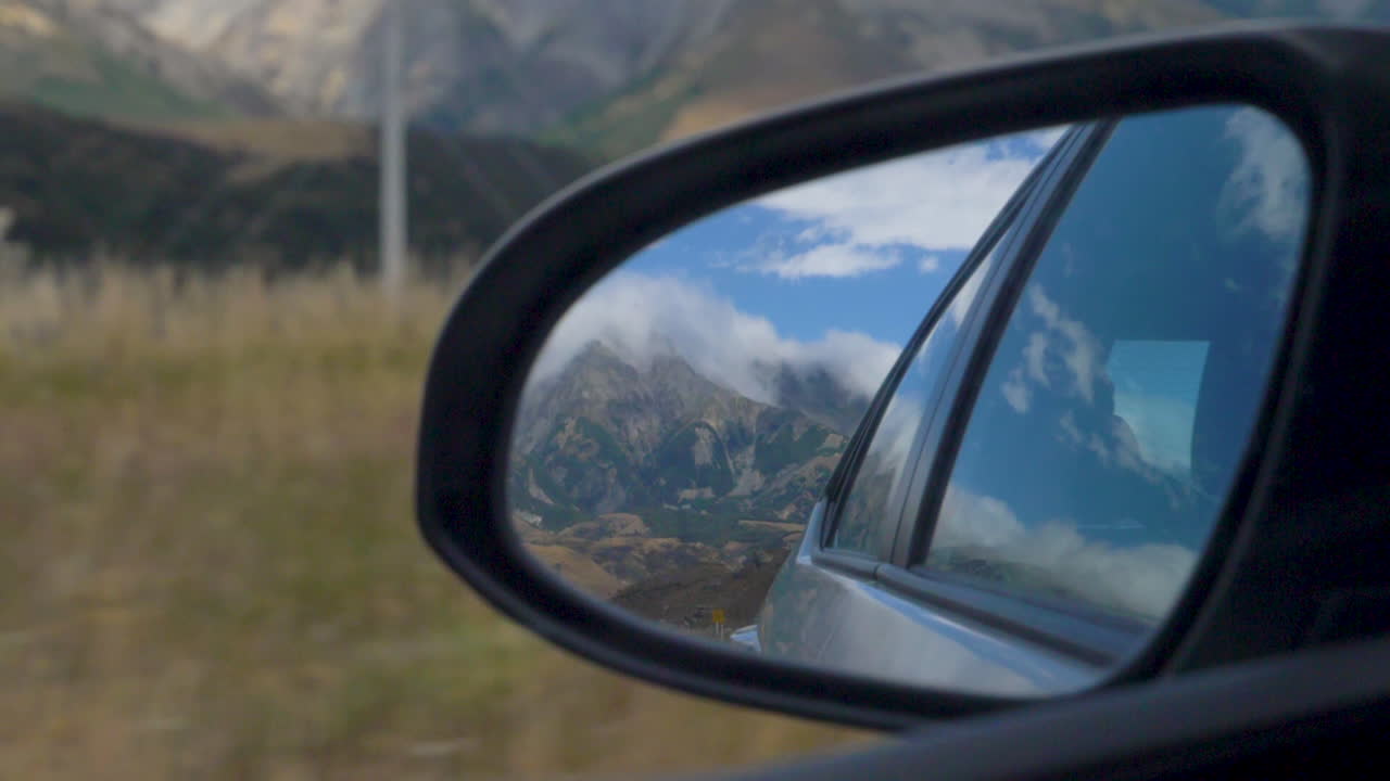 Ripresa al rallentatore di una montagna nello specchietto retrovisore di un'auto - Arthur's Pass, Nuova Zelanda
