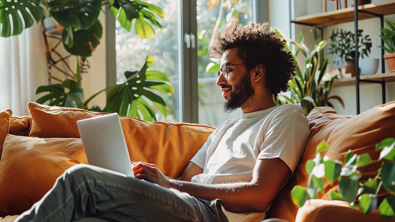 Man relaxing at home working on his laptop