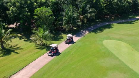 Los-Turistas-Disfrutan-Conduciendo-Un-Carrito-De-Golf-Por-El-Campo-En-Un-Día-Soleado---Toma-Aérea