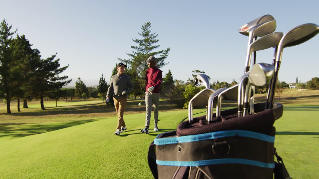 Video of diverse male friends walking on golf field