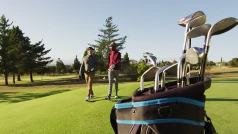 video of diverse male friends walking on golf field