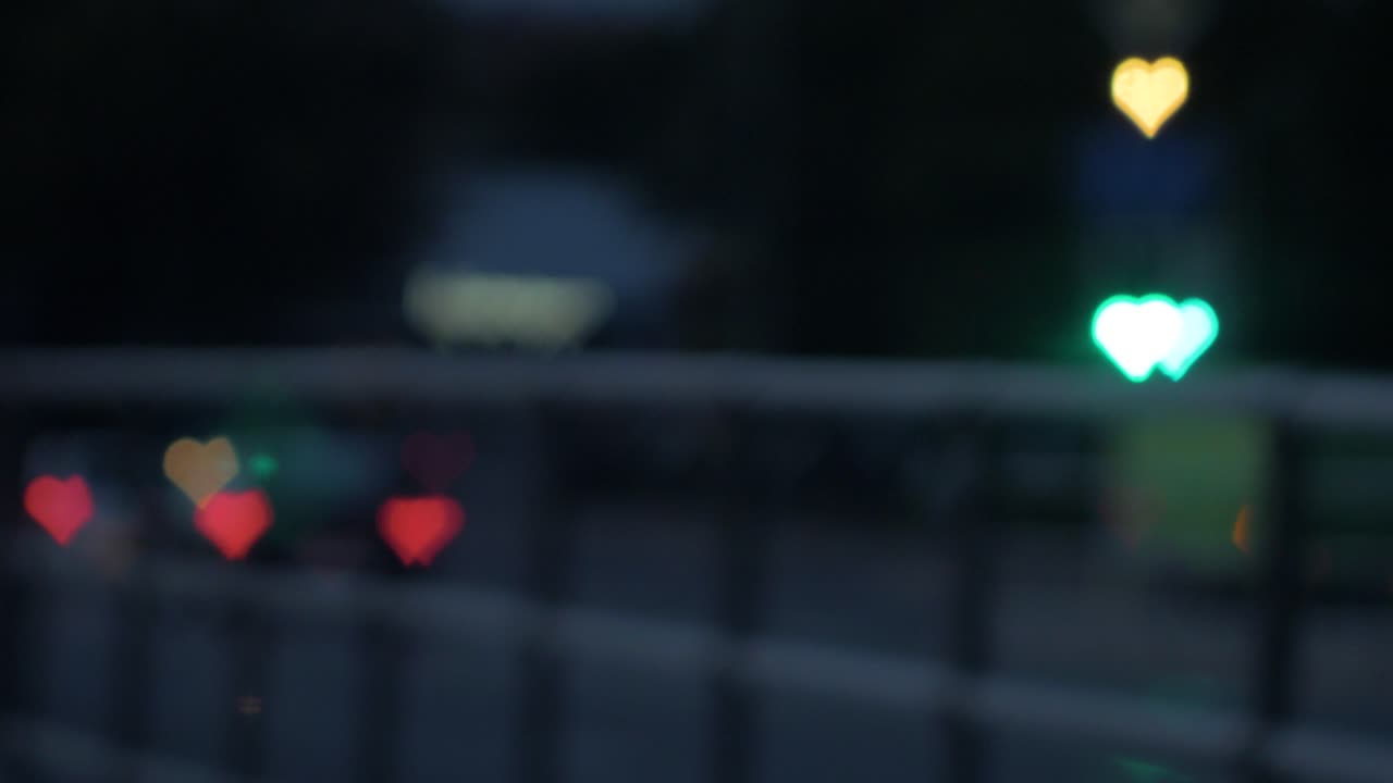 저녁, 발렌타인 데이, 결혼식 날 또는 배경 개념과 같은 소셜 미디어에서 움직이는 자동차와 신호등에서 아름다운 하트 보케