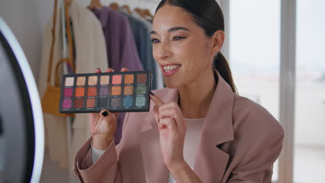 vlogger girl showing eye shadow palette closeup. beauty blogger live streaming