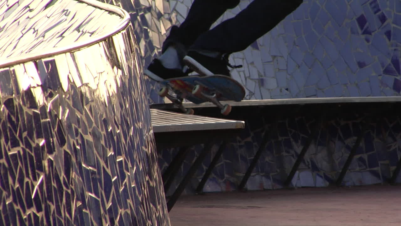 gritty skateboarding, urban freestyle, dynamic board tricks, street grind energy, fearless momentum Urban skater performs a stylish grind on a mosaic bench at sunset