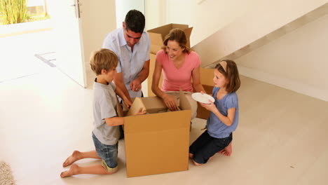 feliz familia abriendo caja en su nuevo hogar