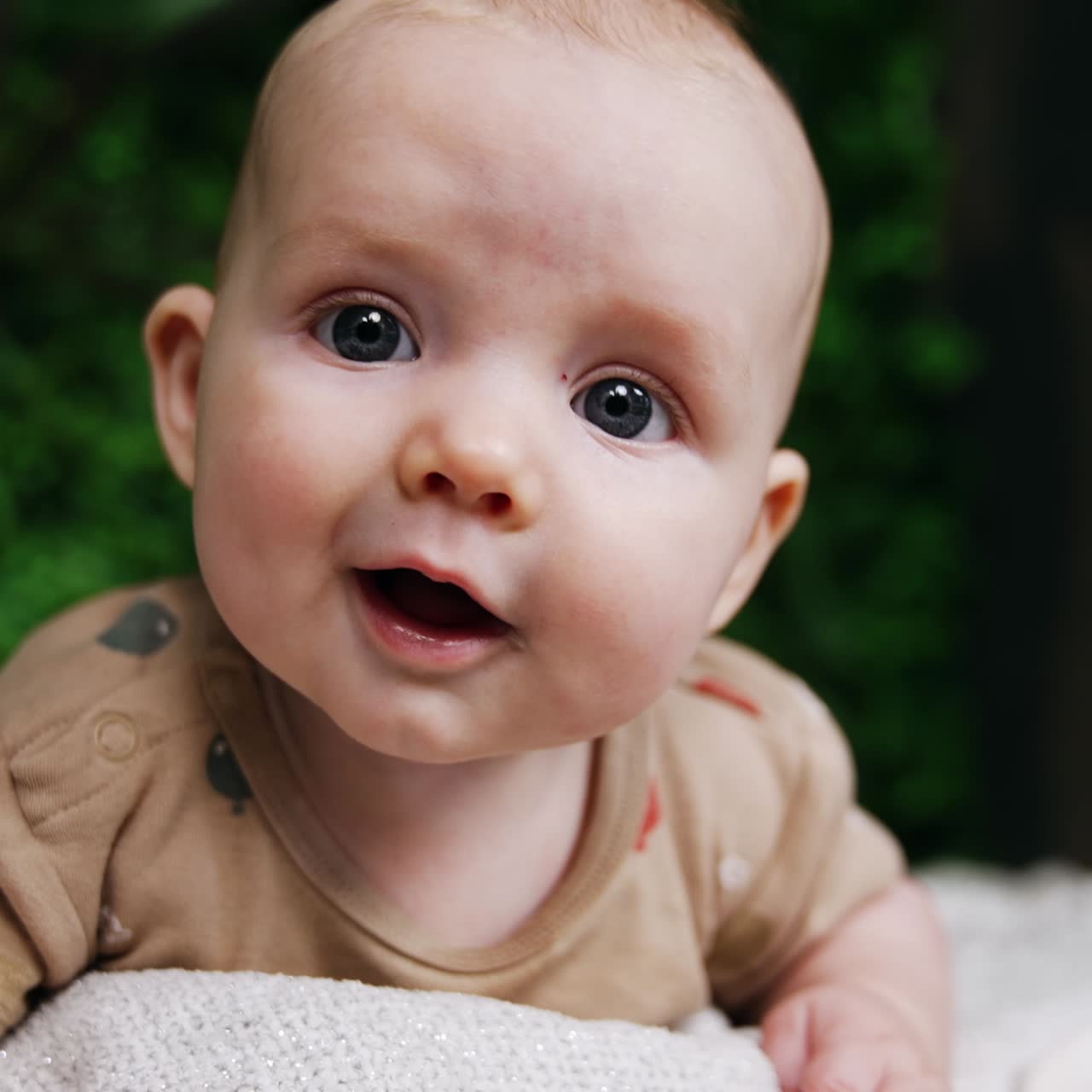 Smiling baby portrait lifestyle. funny little newborn baby on nature lying